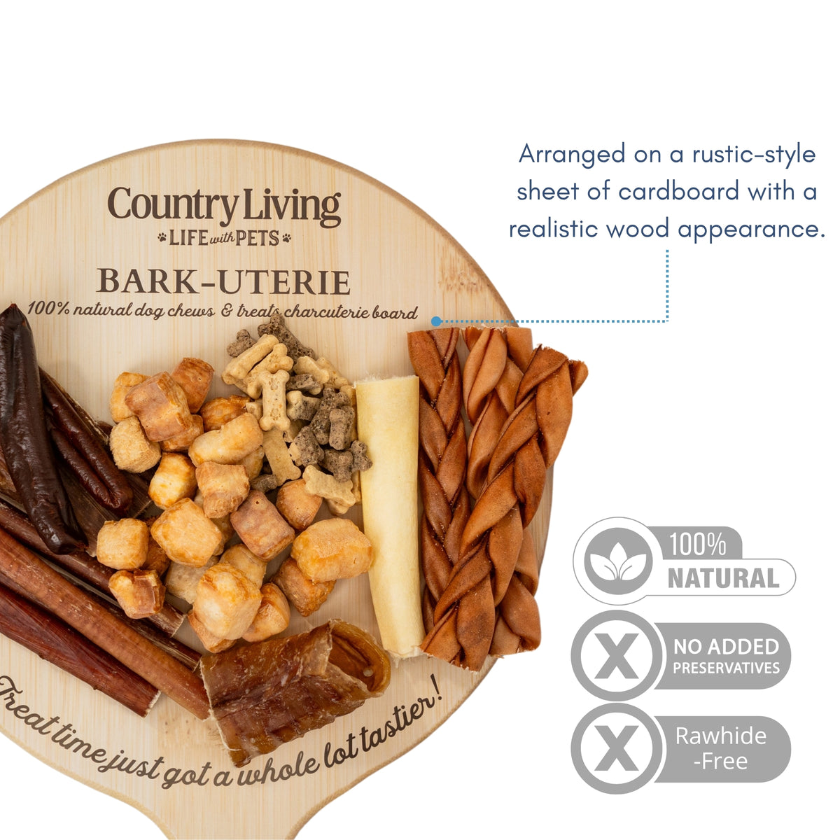 Country Living Bark-Uterie Board dog treat assortment with bully sticks, gullet flats, cow tail, chicken sausages, beef trachea, braided collagen sticks, yak chew puffies, and soft chew biscuits arranged on a rustic wood-look cardboard board.